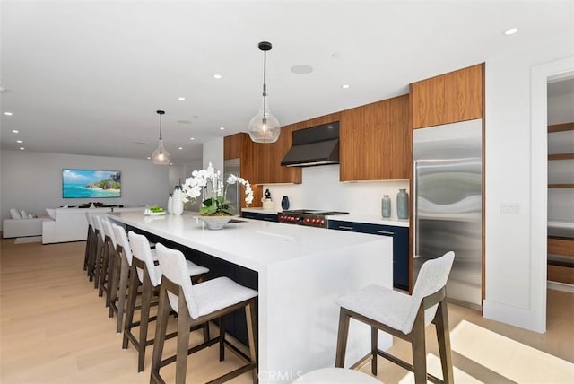 32531 Azores Rd, Dana Point, CA 92629 - kitchen with stainless steel built in refrigerator, extractor fan, brown cabinetry, light countertops, and light wood-style flooring