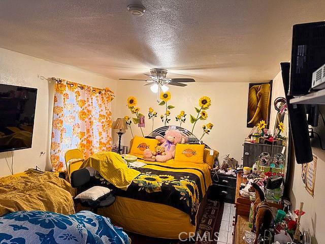 bedroom featuring a textured ceiling and ceiling fan