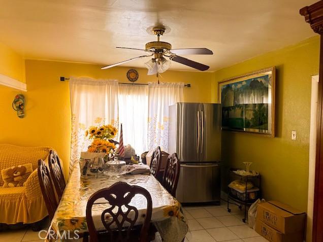 dining space featuring ceiling fan and light tile patterned floors