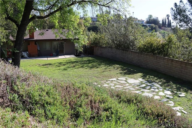 view of yard with fence and a patio