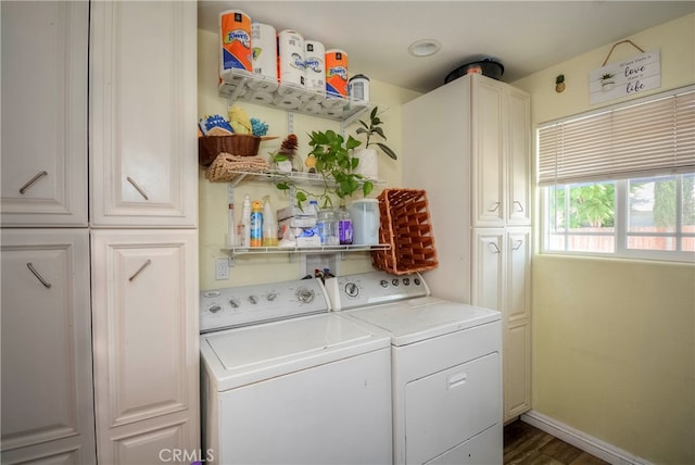 washroom featuring cabinets, dark hardwood / wood-style floors, and washing machine and dryer