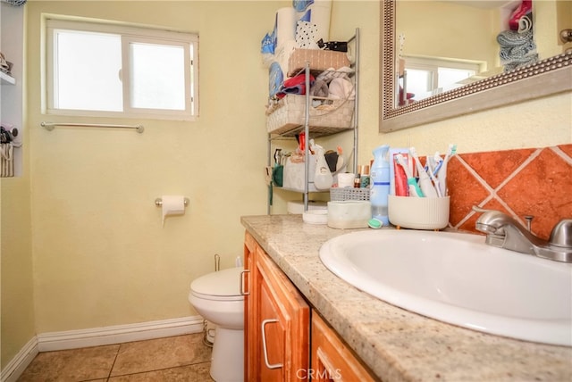 bathroom with tile patterned flooring, plenty of natural light, vanity, and toilet