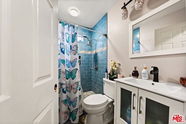 bathroom featuring curtained shower, vanity, a textured ceiling, and toilet