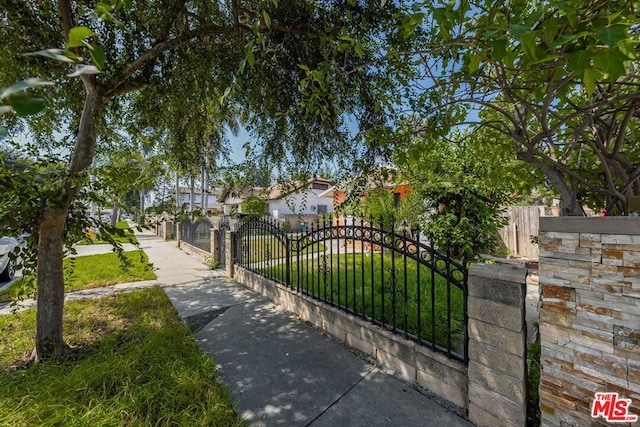 view of gate with a lawn