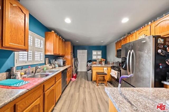 kitchen featuring stainless steel appliances, light hardwood / wood-style flooring, and sink