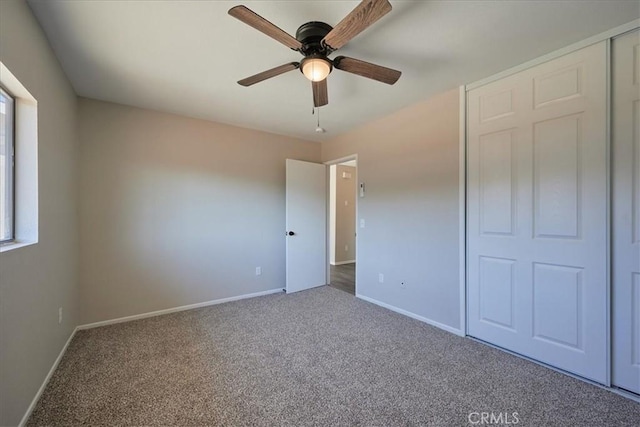 unfurnished bedroom featuring carpet, ceiling fan, and a closet