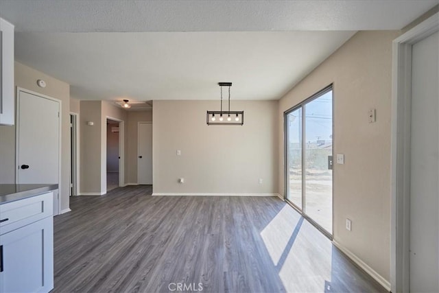 unfurnished dining area with dark wood-type flooring