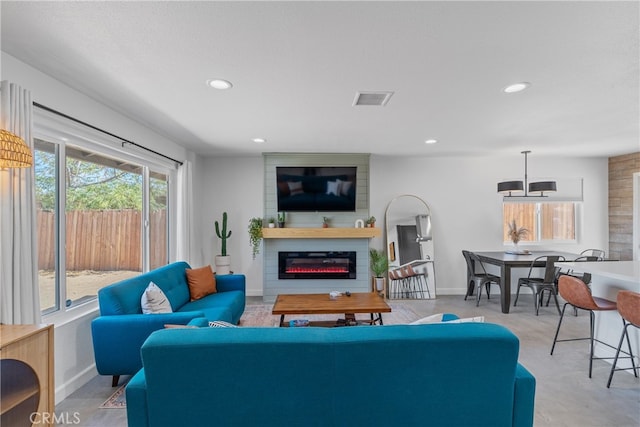 living room featuring a fireplace and plenty of natural light