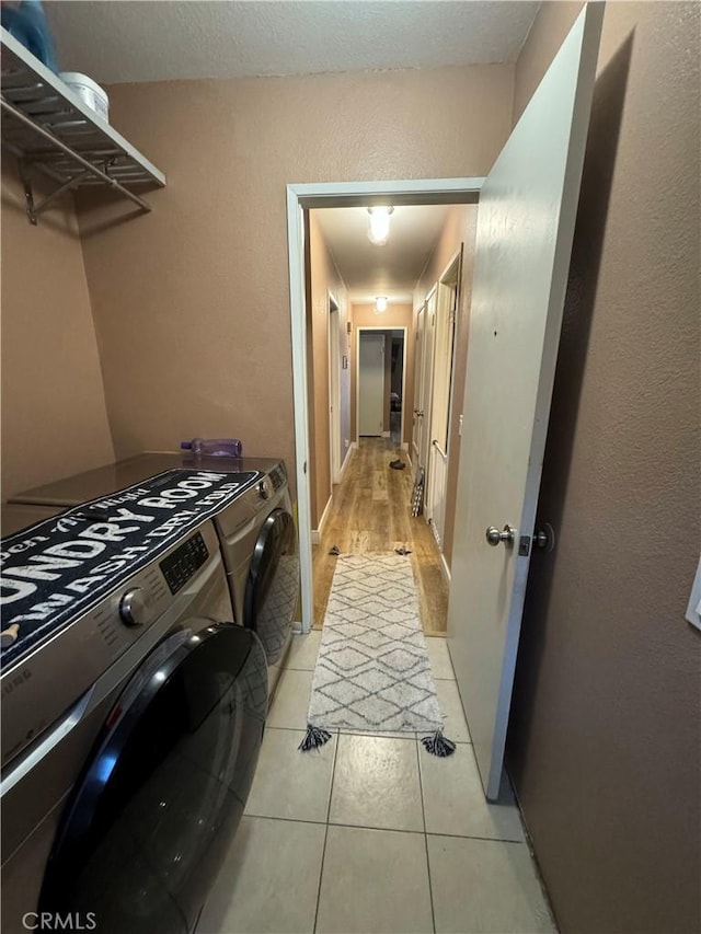 laundry room with washer and dryer and light tile patterned flooring