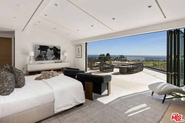 bedroom with light wood-type flooring, vaulted ceiling, and a water view