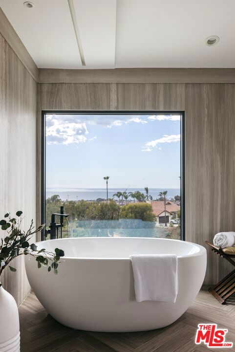 bathroom with a water view and a bathtub