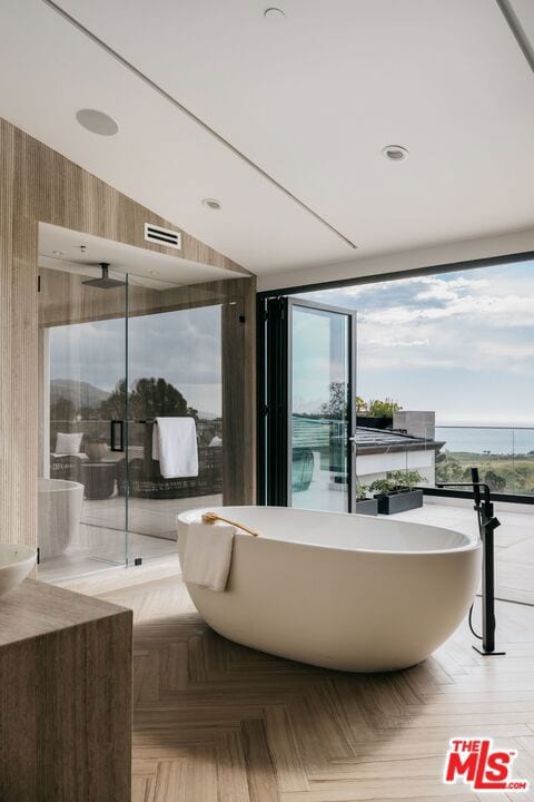 interior space featuring a water view, parquet floors, and a bath