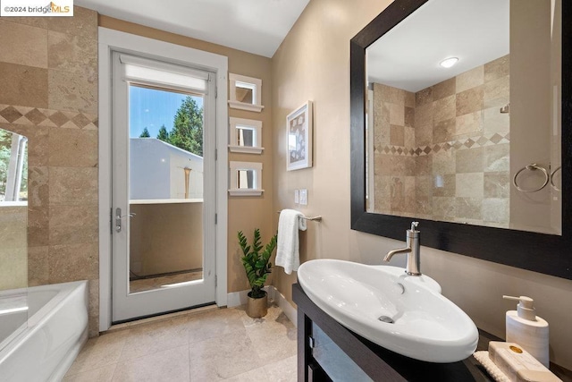 bathroom featuring a healthy amount of sunlight, vanity, and independent shower and bath