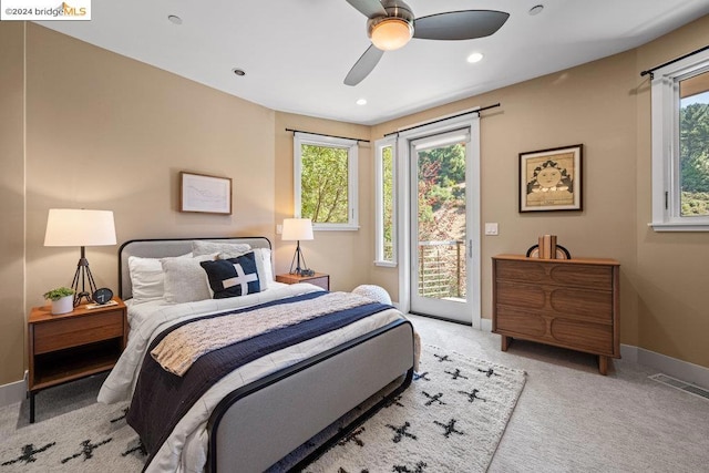 carpeted bedroom with access to outside, multiple windows, and ceiling fan