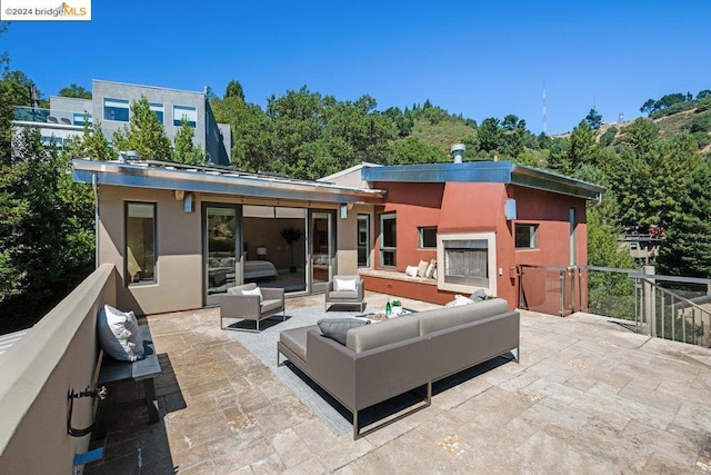 rear view of property featuring outdoor lounge area and a patio area