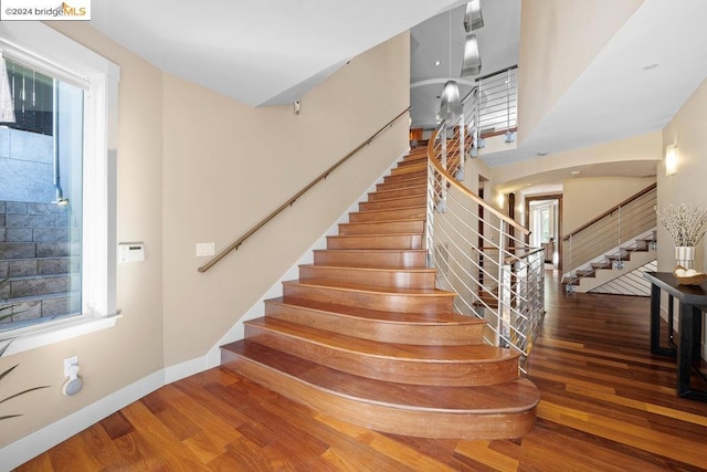 staircase with hardwood / wood-style floors and a healthy amount of sunlight