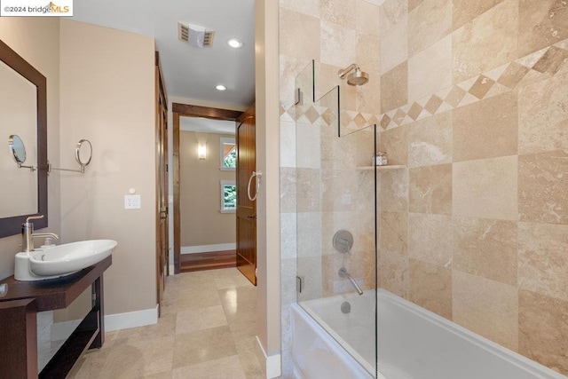 bathroom with bath / shower combo with glass door, vanity, and tile patterned flooring