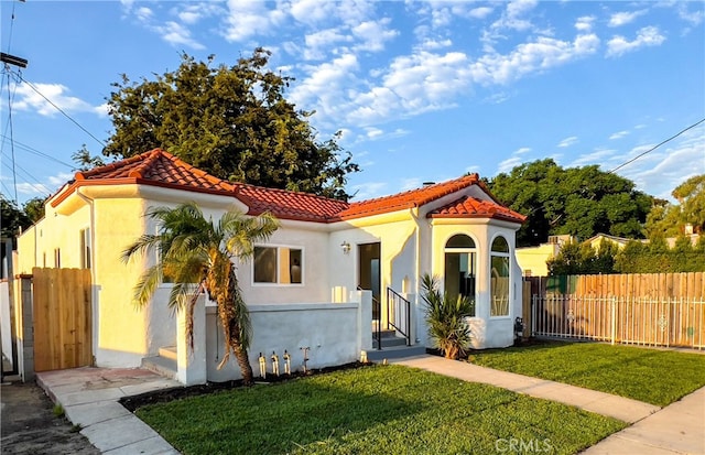 mediterranean / spanish house featuring a front lawn