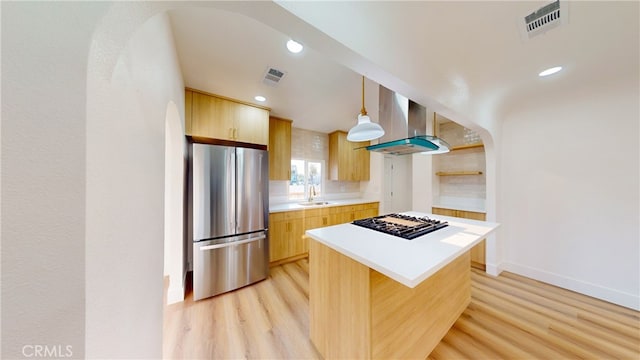 kitchen featuring sink, hanging light fixtures, a kitchen island, stainless steel appliances, and exhaust hood