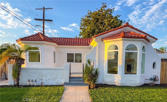 mediterranean / spanish home featuring a front lawn