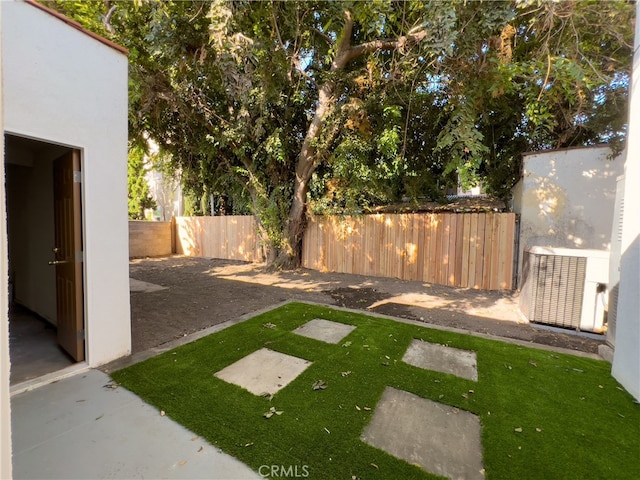 view of yard with central AC unit and a patio area