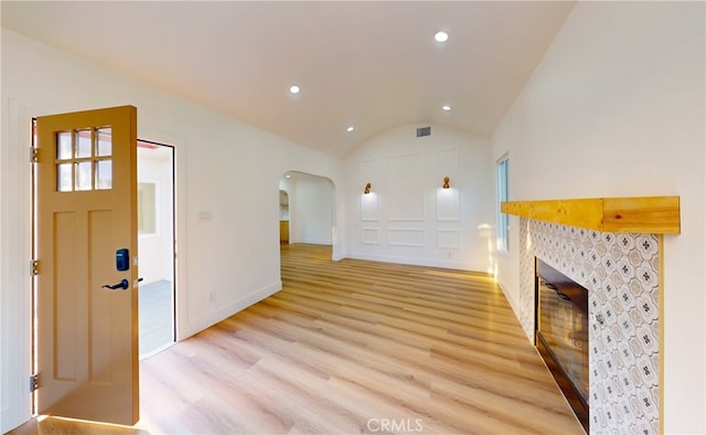 unfurnished living room with light wood-type flooring and vaulted ceiling