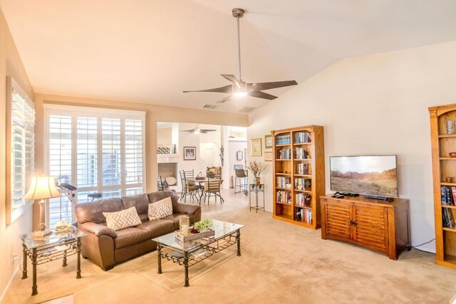 carpeted living room featuring ceiling fan and vaulted ceiling