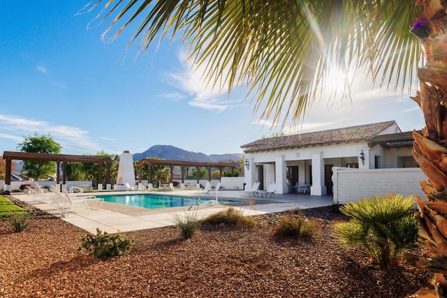 view of pool featuring a mountain view, a patio, and an outbuilding