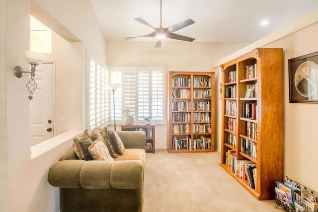 living area with carpet and ceiling fan