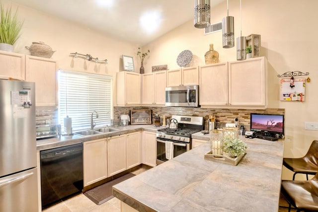 kitchen with sink, backsplash, tile countertops, decorative light fixtures, and appliances with stainless steel finishes