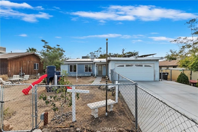 ranch-style house featuring a gate, driveway, roof mounted solar panels, a garage, and stucco siding