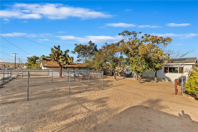 view of front of property with fence, roof mounted solar panels, and stucco siding