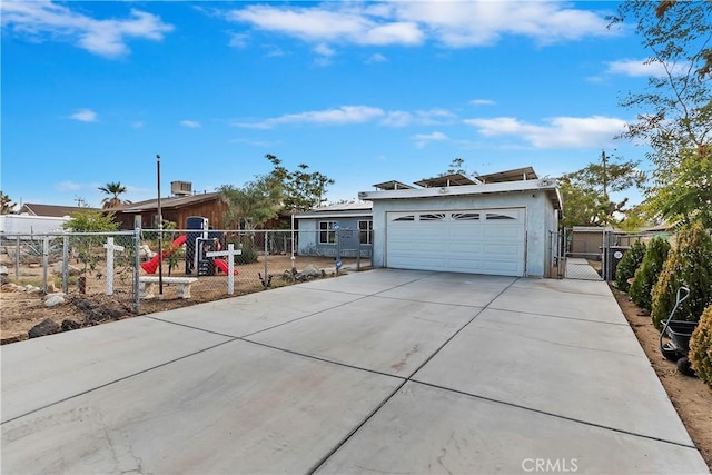 view of front of house with a gate, stucco siding, fence private yard, and a garage