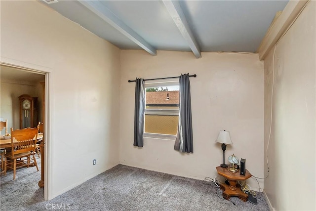 spare room with beam ceiling and carpet flooring