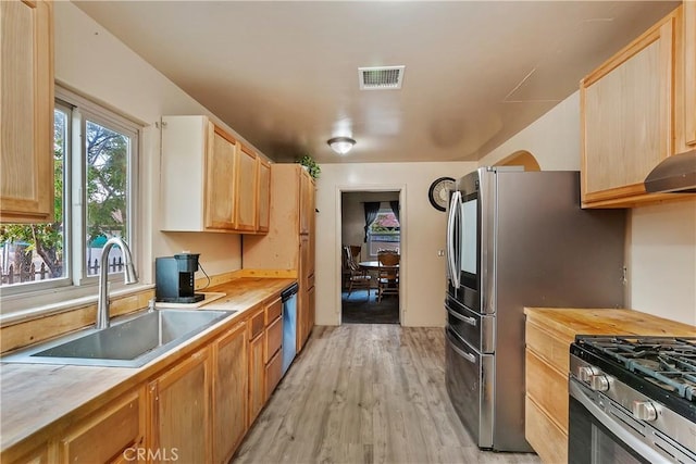 kitchen featuring wooden counters, visible vents, a sink, light wood-style flooring, and appliances with stainless steel finishes