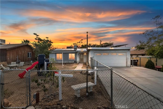 view of front facade featuring roof mounted solar panels, an attached garage, a fenced backyard, and driveway