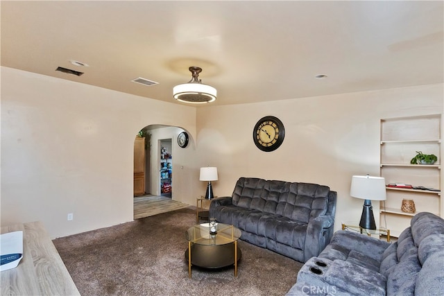 living room with dark colored carpet