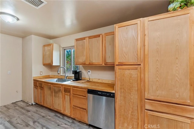 kitchen featuring light brown cabinets, a sink, dishwasher, light wood finished floors, and visible vents
