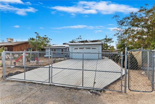 view of front facade with fence, a gate, and concrete driveway