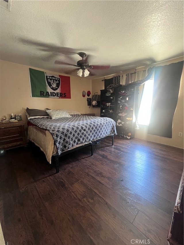 bedroom with ceiling fan, a textured ceiling, and hardwood / wood-style flooring