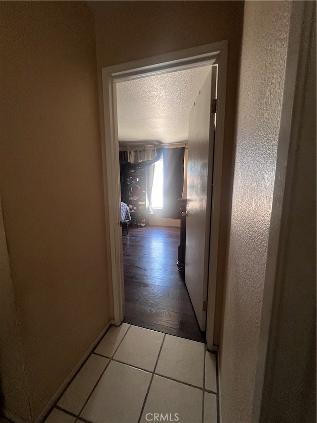 hallway with hardwood / wood-style flooring and a textured ceiling