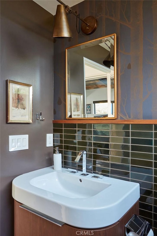 bathroom featuring vanity and backsplash