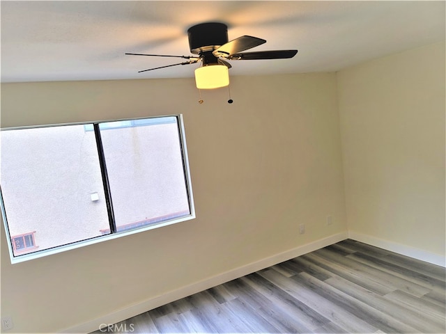 spare room with vaulted ceiling, ceiling fan, and hardwood / wood-style flooring