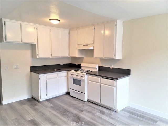 kitchen with white cabinets, white gas stove, light wood-type flooring, and custom exhaust hood