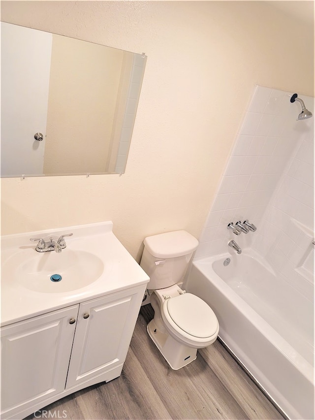 full bathroom featuring wood-type flooring, shower / bath combination, vanity, and toilet