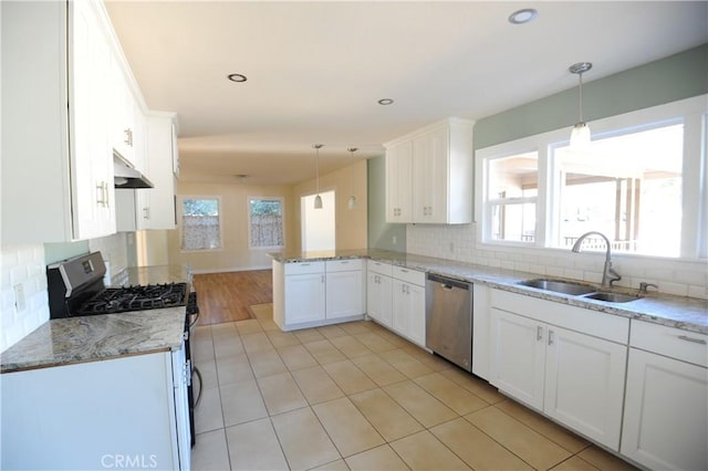 kitchen featuring kitchen peninsula, hanging light fixtures, sink, white cabinetry, and stainless steel appliances