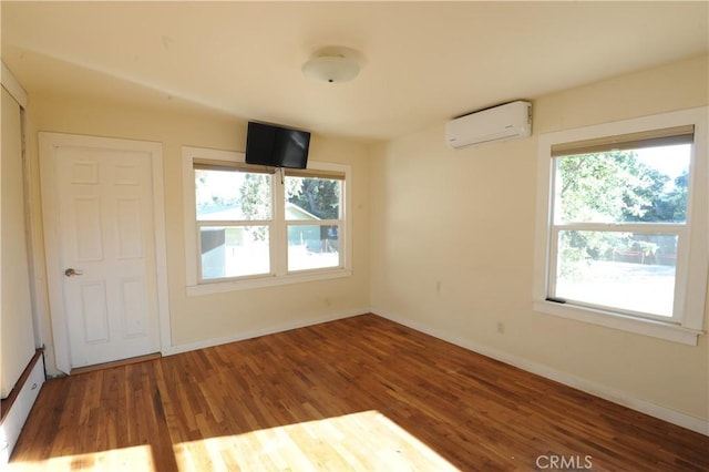 spare room featuring hardwood / wood-style flooring and a wall mounted AC