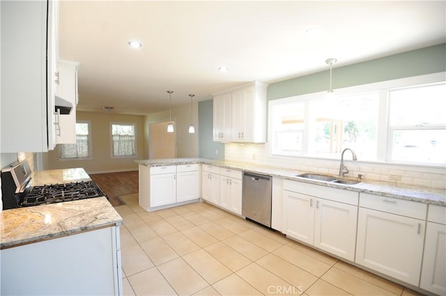 kitchen with kitchen peninsula, hanging light fixtures, appliances with stainless steel finishes, sink, and white cabinetry