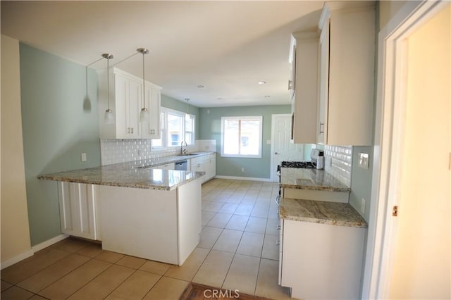 kitchen with kitchen peninsula, decorative light fixtures, sink, backsplash, and white cabinetry