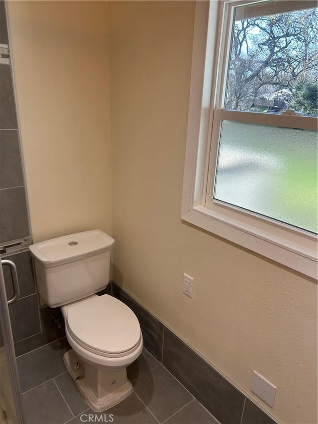 bathroom featuring toilet, tile patterned floors, and plenty of natural light